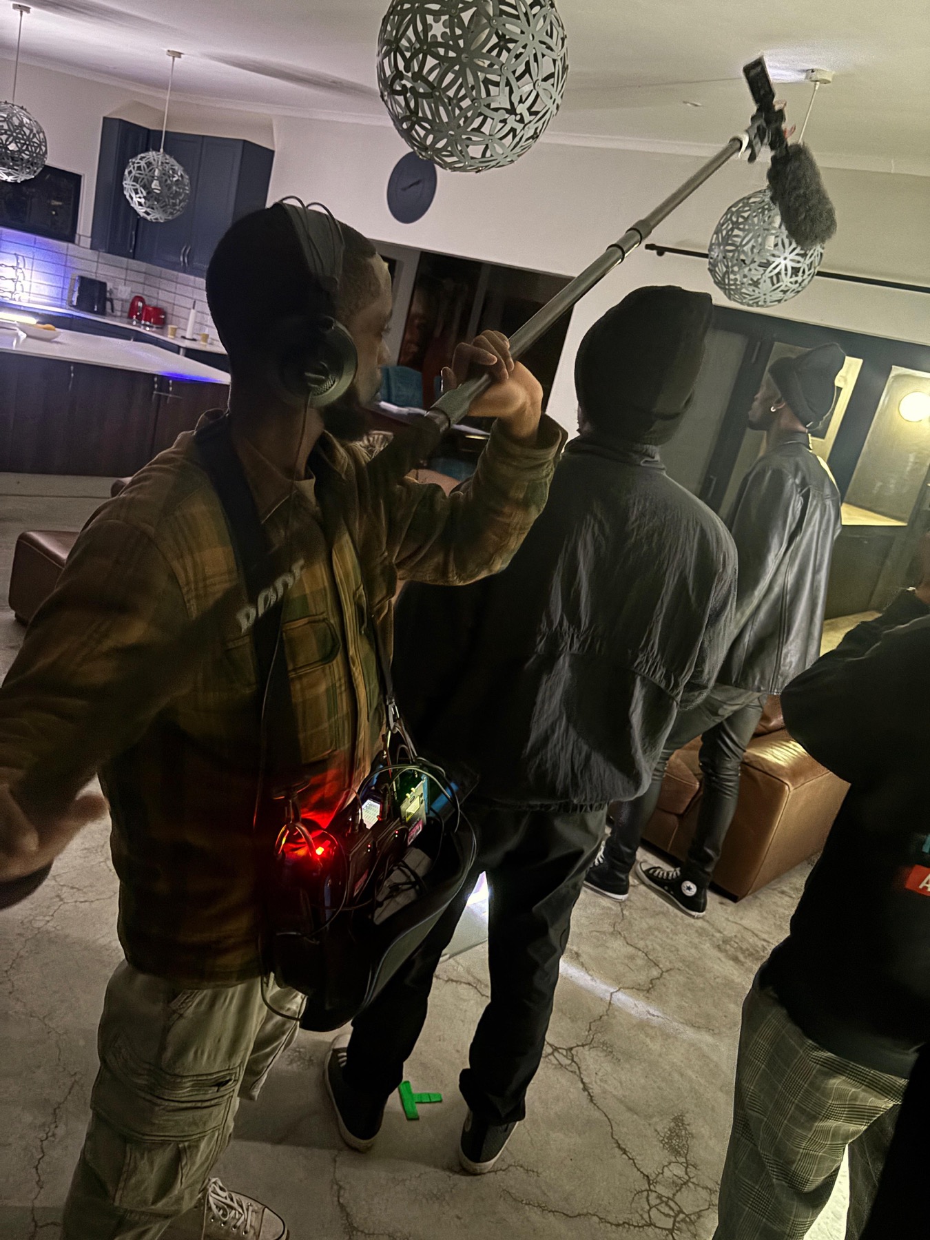 Boom operator and crew recording sound on a Black Orbit Studios set